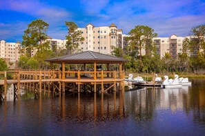 Guests can enjoy serene lakeside views from a wooden gazebo overlooking the calm water.
