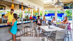 Eine Außenbar mit Korbmöbeln und hängenden Pendelleuchten.