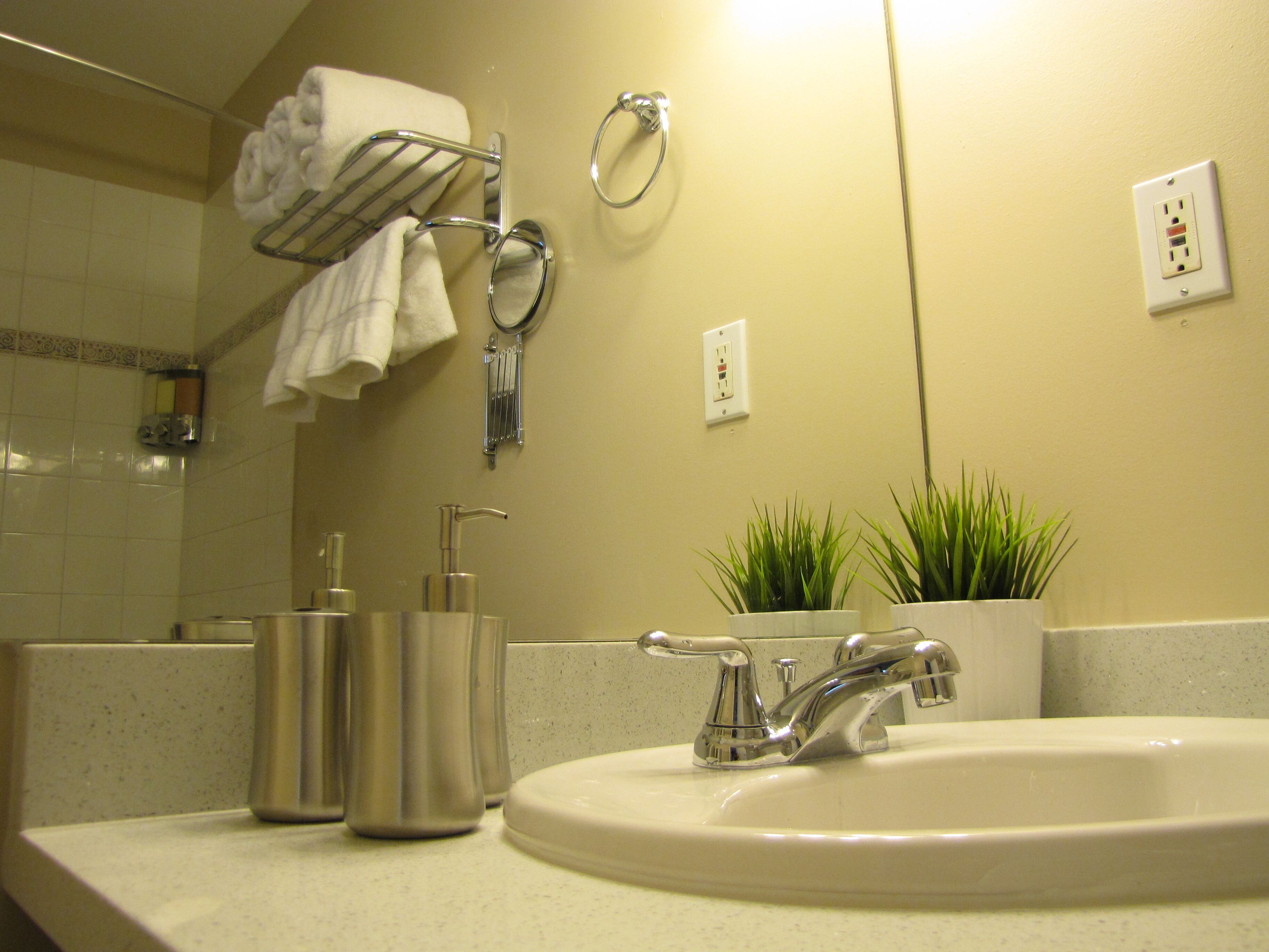 A bathroom with a sink, towel rack, and a mirror.