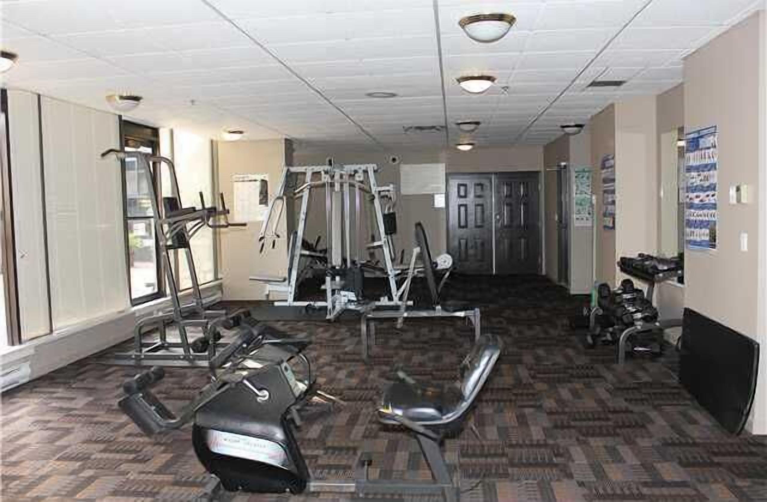 A gym with exercise equipment, a treadmill, and a stationary bike.