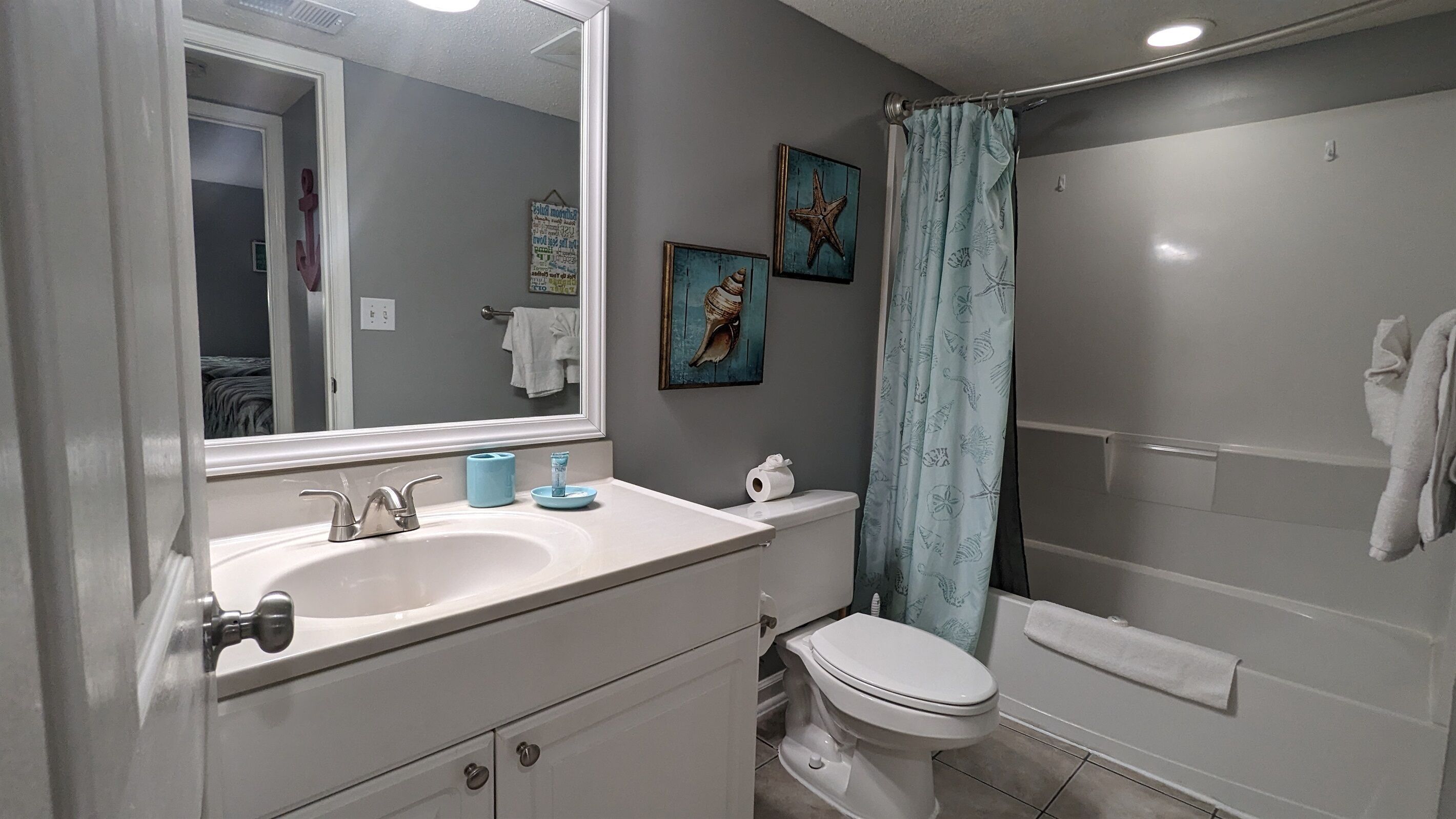 A bathroom with a sink, toilet, and shower.