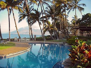 A pool area with palm trees and a view of the ocean. - Maui Rendezvous Ekahi 33A, 1bd/2bth, Luxury, Remodel, Beach 3min walk (Wailea, Maui)