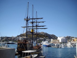 Docked at the pier, a historic ship awaits, surrounded by a bustling marina and scenic coastal views.