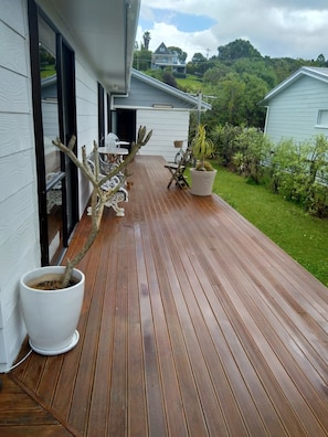 Une terrasse en bois agrémentée de plantes en pot et de mobilier d’extérieur.