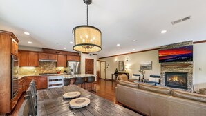 A modern kitchen with wooden cabinets, a large island, and a stone backsplash. - Steps to Heavenly, Lake & More | Tahoe Woods #101 (South Lake Tahoe)