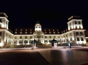 A large, illuminated building with a central dome and symmetrical wings, featuring a grand entrance and a clock tower. - Residence Seeblick 14 with lateral Baltic Sea view - Studio beach shell / with (Sellin)