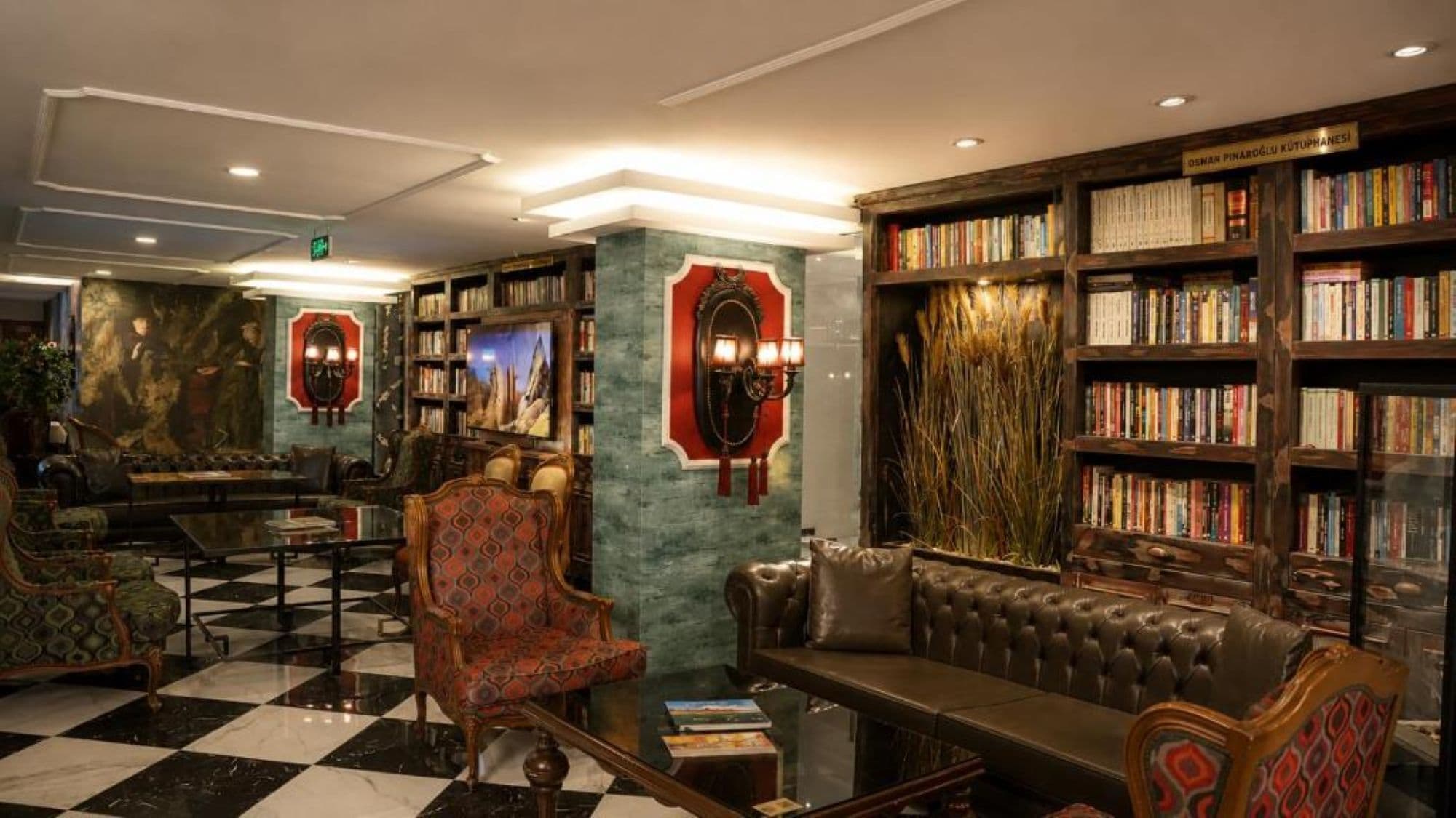 Una biblioteca con sofás de cuero, suelo a cuadros y estanterías llenas de libros.