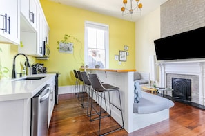 A kitchen with a bar area, a fireplace, and a dining nook.