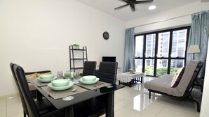 A modern living room with a dining area, a sofa, a TV, and a large window with curtains.
