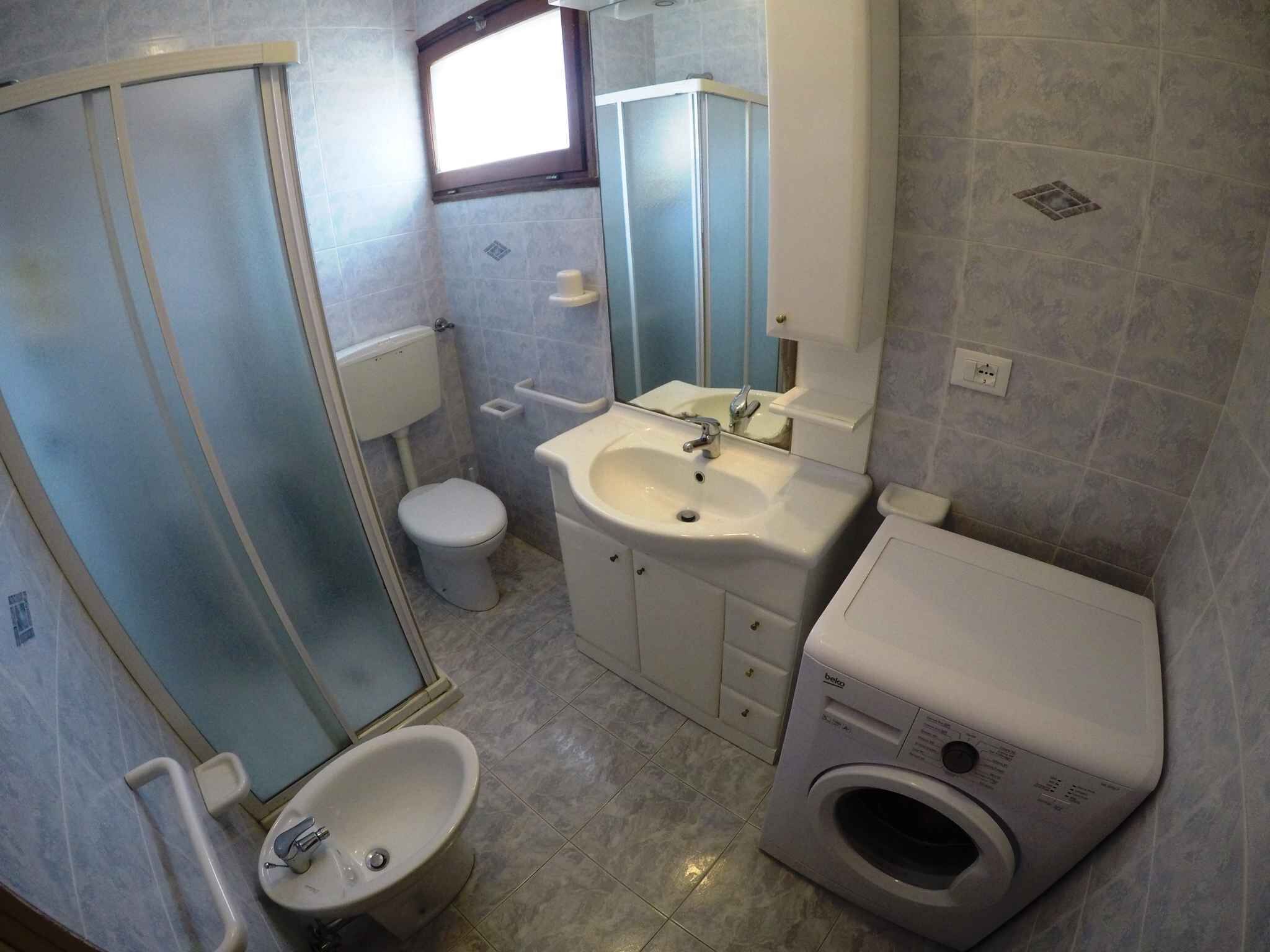 Une petite salle de bain comprenant des toilettes, un lavabo, un bidet et un lave-linge.