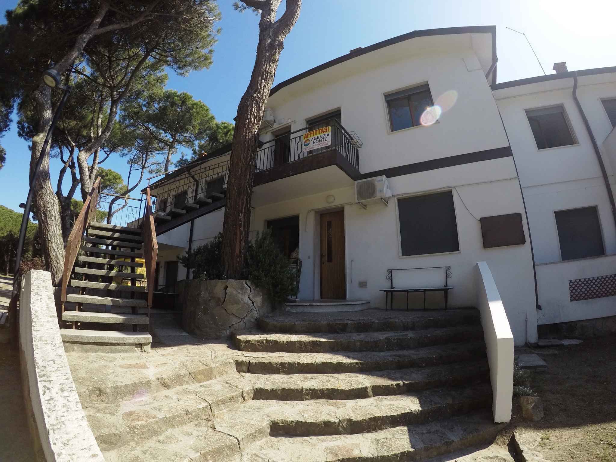 Um edifício de vários andares com uma escadaria de pedra que leva à entrada.