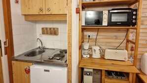 A compact kitchen with a Frigidaire refrigerator, a stove, a sink, a microwave, a toaster, and a coffee maker. - Charming studio for 2-3 people, 17m² south-facing in Valfréjus (Valfréjus)