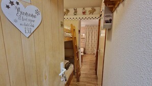 A narrow wooden hallway with a bunk bed and a heart-shaped welcome sign. - Charming studio for 2-3 people, 17m² south-facing in Valfréjus (Valfréjus)