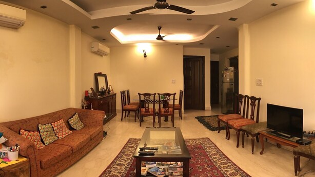 A living room with a sofa, coffee table, TV, and dining area. - The place to stay when you are in New Delhi (New Delhi)