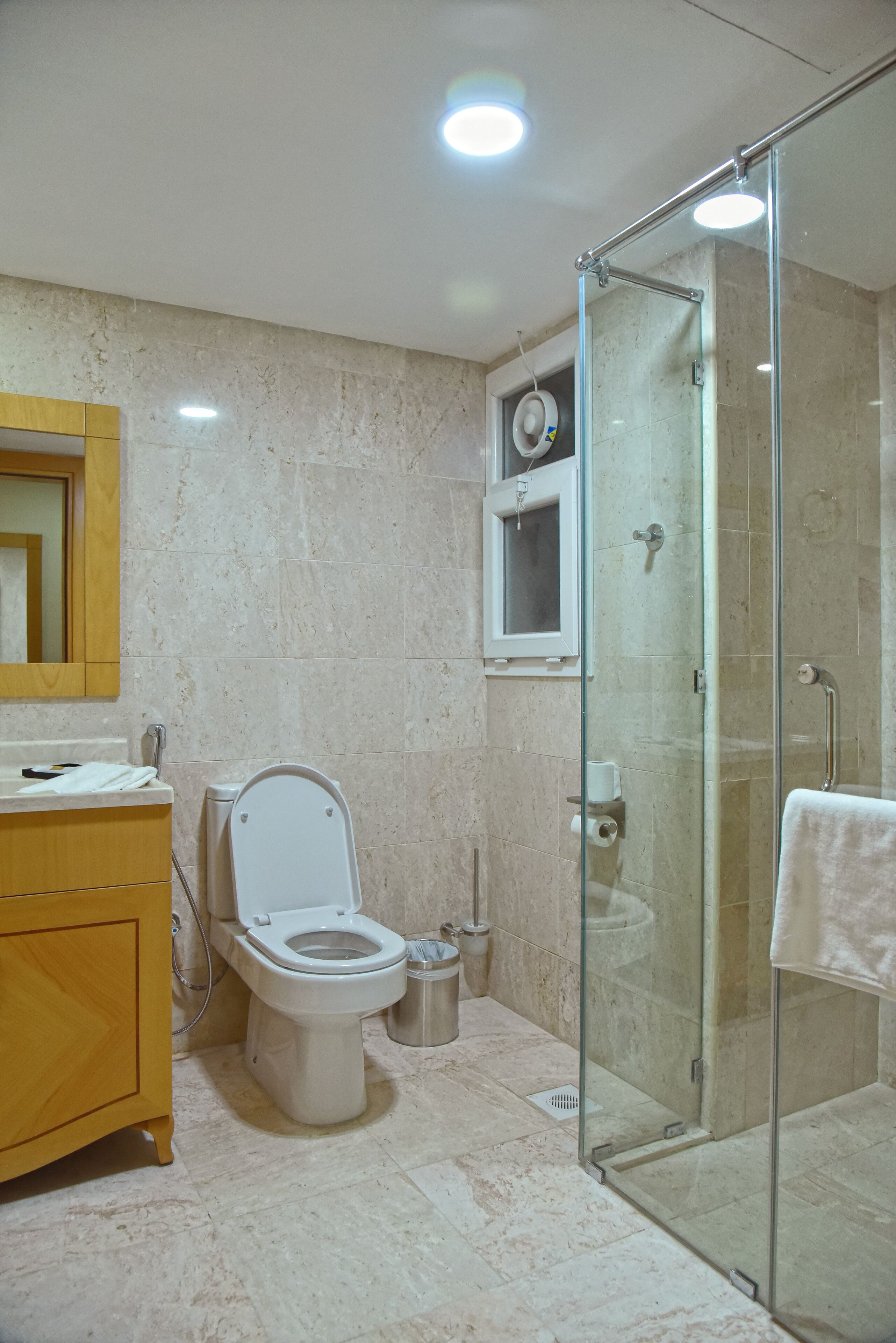 Un baño con inodoro, lavamanos y cabina de ducha de vidrio.