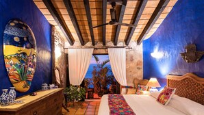 A bedroom with a bed, a dresser, a ceiling fan, and a view of the outdoors. - 2 BR romantic Penthouse in Conchas Chinas with amazing views & beach access (Puerto Vallarta)
