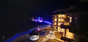 A building with multiple balconies and a well-lit outdoor area with blue lights.