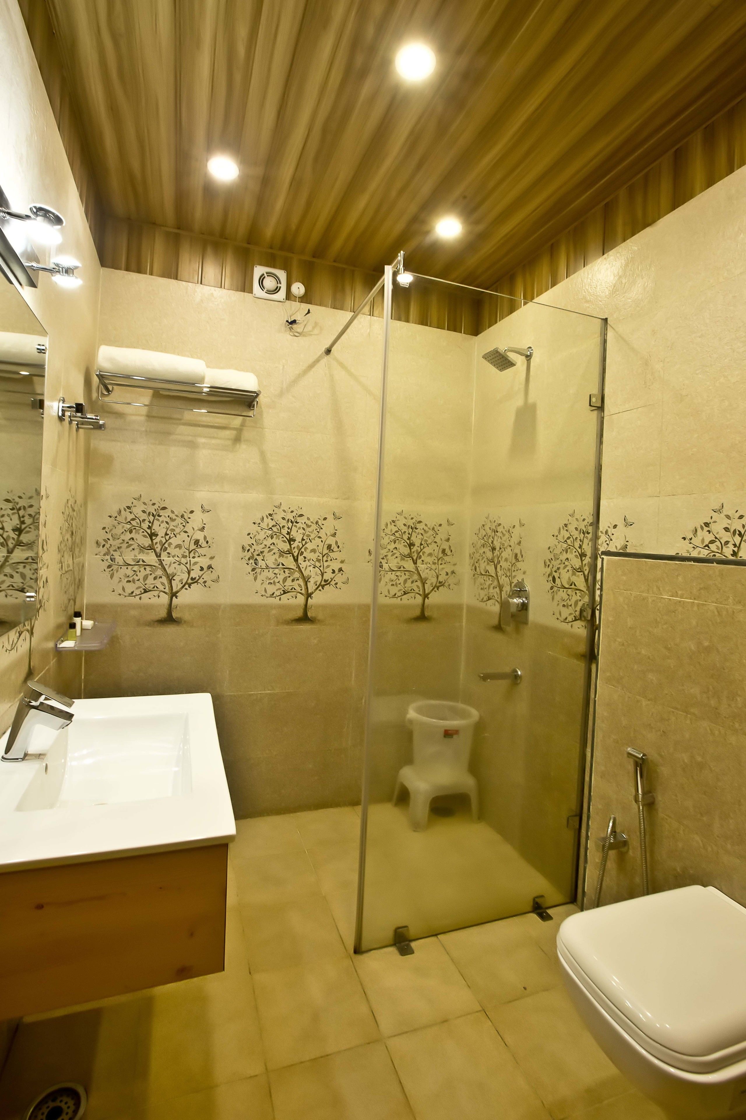 A bathroom with a glass-enclosed shower, a sink, and a toilet.