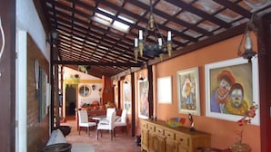 A cozy interior with a wooden ceiling, a dining area with chairs and a table, and a bar area with a counter and stools. - Aloha Hostel Cabo Frio (Cabo Frio)
