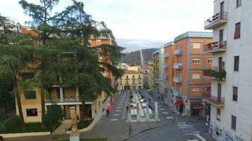 A street view with buildings, a pedestrian crossing, and a statue in the center.