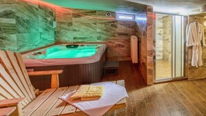 A spa room with a hot tub, wooden seating, and a glass shower enclosure. - VeLa (Malý Slavkov)