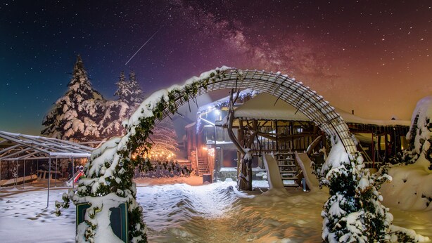A snow-covered outdoor area with a metal archway and snow-covered trees. - VeLa (Malý Slavkov)