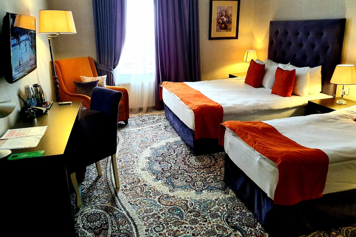 Deluxe Triple Room | Minibar, in-room safe, desk, blackout drapes