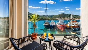 A balcony with wicker chairs, a small table with croissants, a potted plant, and a view of boats at a marina. - Beachront Luxury Villa w/rooftop pool, gym + spa Only 20 Min. From Split Airport (Vinišce)