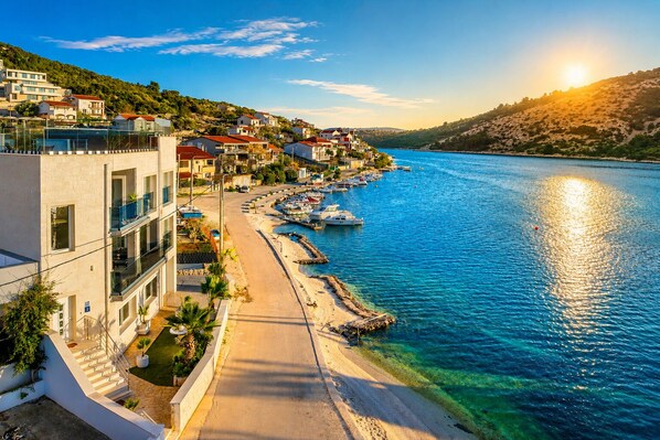 A coastal town with buildings along a waterfront, a clear sky, and boats docked near the shore. - Beachront Luxury Villa w/rooftop pool, gym + spa Only 20 Min. From Split Airport (Vinišce)