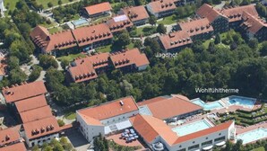 An aerial view of a hotel with multiple buildings, a swimming pool, and surrounding greenery. - Apparthotel Jagdhof (Bad Griesbach im Rottal)