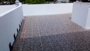 Una terraza con piso de baldosas estampadas y paredes blancas.