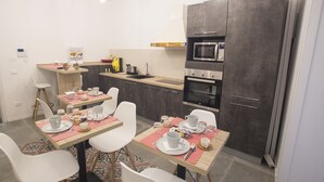 Een moderne keuken met een eethoek voor vier personen, inclusief een tafel met stoelen, een magnetron en een inbouwoven.