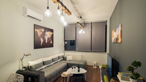 A modern living room with a grey sofa, a round coffee table, and a world map artwork.