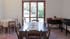 A dining area with a wooden table, chairs, and a view through a window.