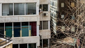 A multi-story building with balconies, air conditioning units, and a mix of window styles. - Emerald Suite (Athens)
