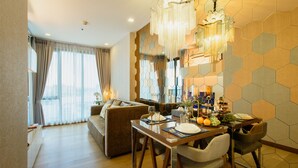 A modern dining area with a wooden table, chairs, and a chandelier. - ★Luxury1BR 5mins Chiang Mai Night Bazaar Roof Pool (Chiang Mai)