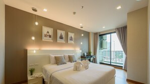 A hotel room with a large bed, a nightstand, a desk, and a balcony with a view of the city. - ★Luxury1BR 5mins Chiang Mai Night Bazaar Roof Pool (Chiang Mai)