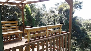 A wooden deck with benches and a railing, overlooking a forested area. - Naturalist's Cloud Forest Retreat (Monteverde)