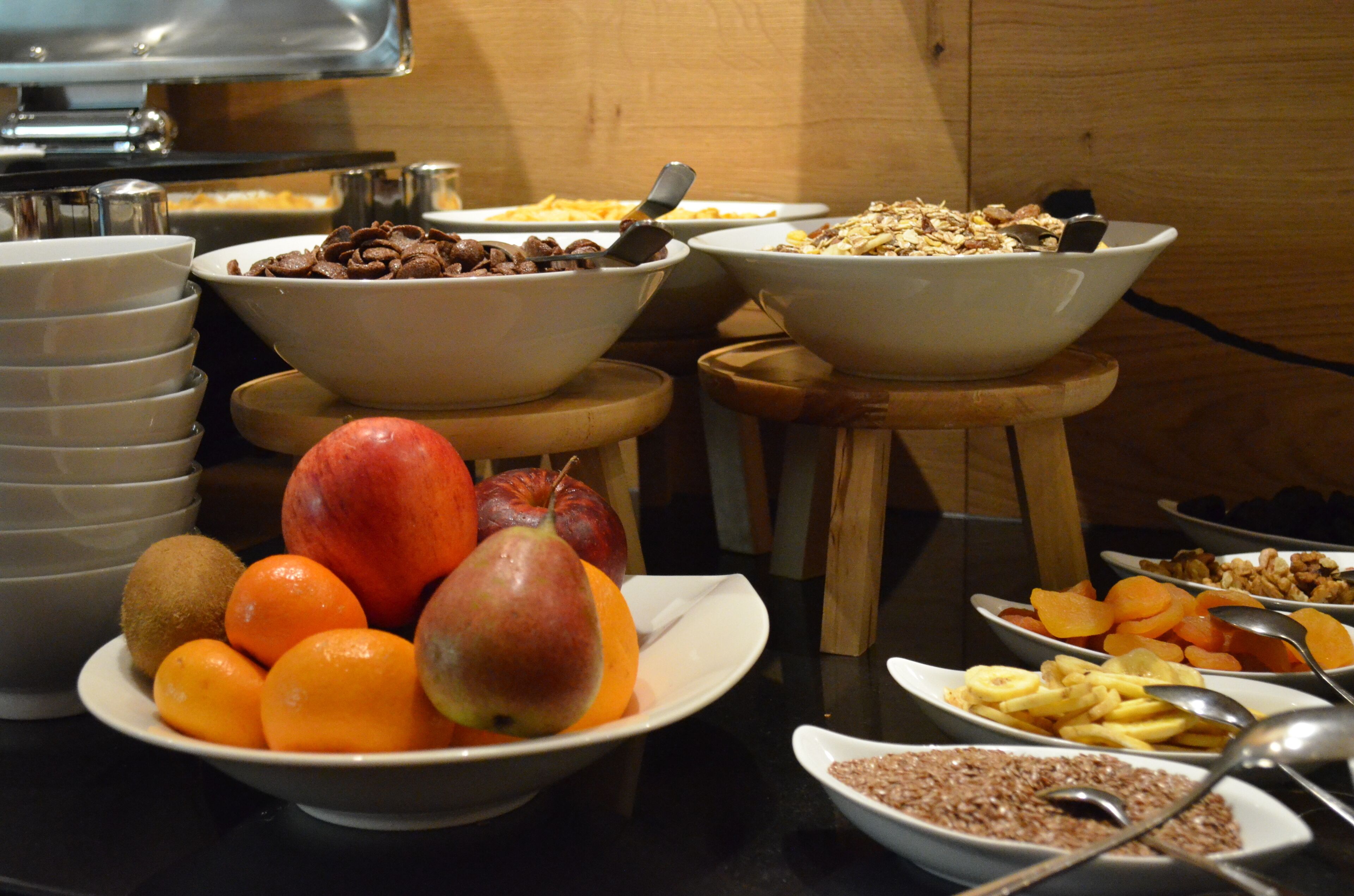 Un bufé con diversos alimentos, entre ellos frutas, cereales y frutos secos.