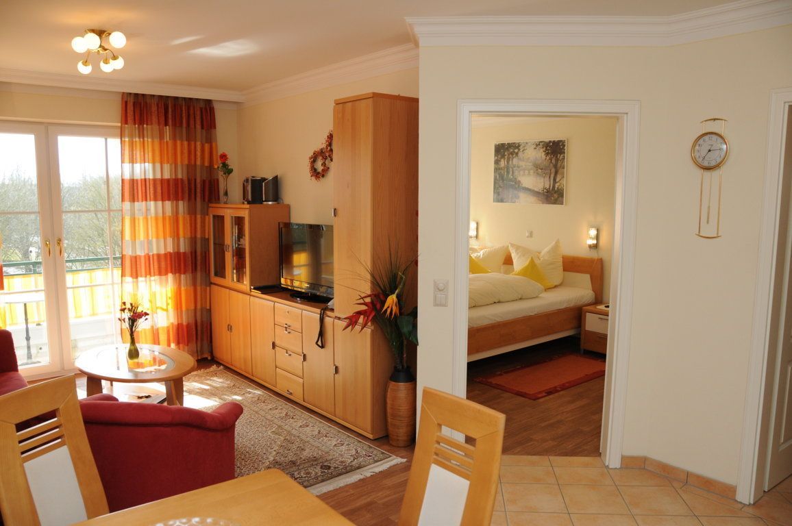 A cozy living room with a dining area, a kitchen, and a bedroom.