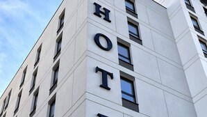 Un moderno edificio de hotel con un llamativo letrero que dice 'HOTEL' en la fachada.