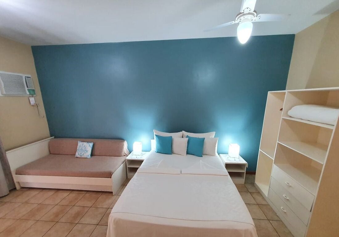 Une chambre à coucher comprenant un lit, un canapé, une table de chevet et une armoire.