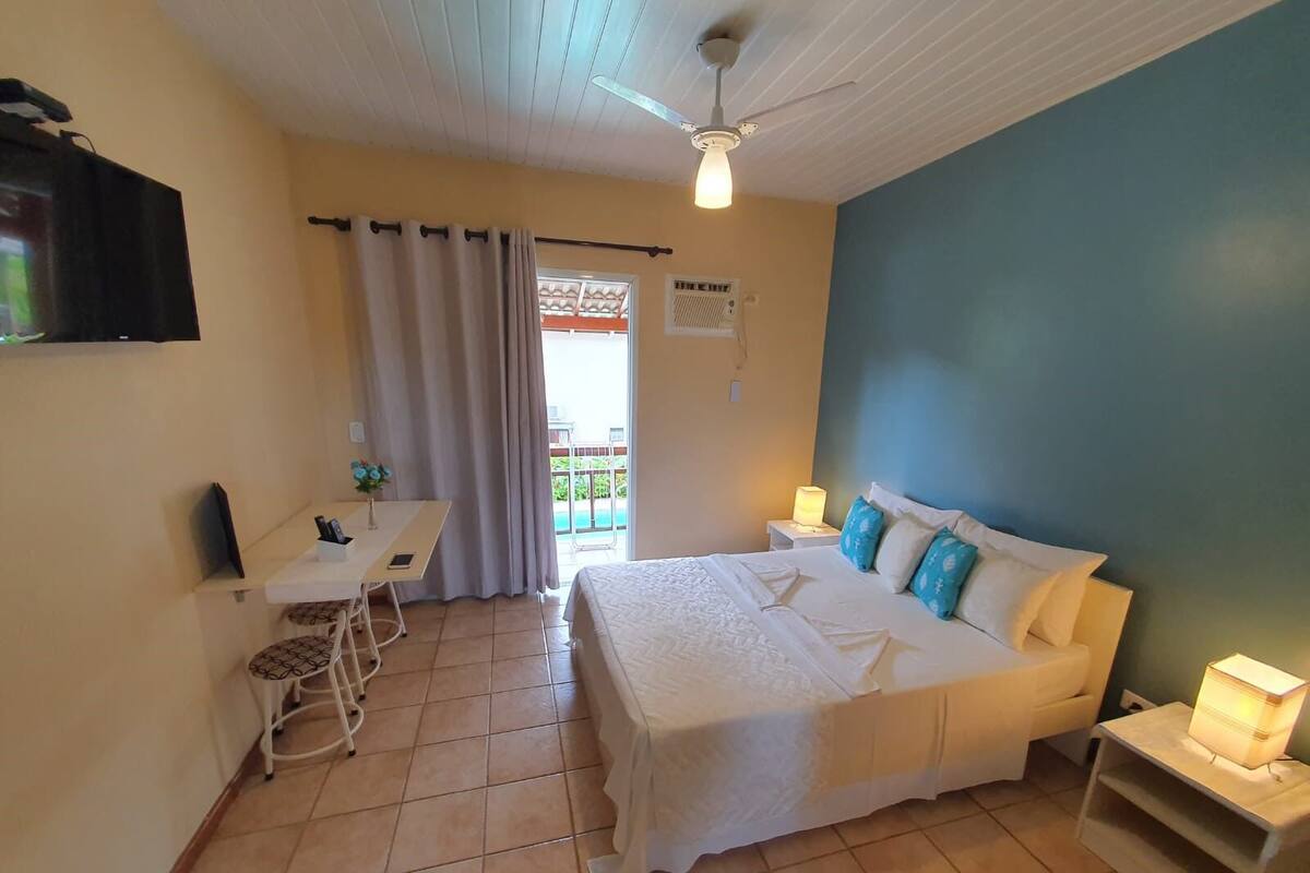 Une chambre à coucher comprenant un lit, des tables de chevet, un bureau et une chaise.