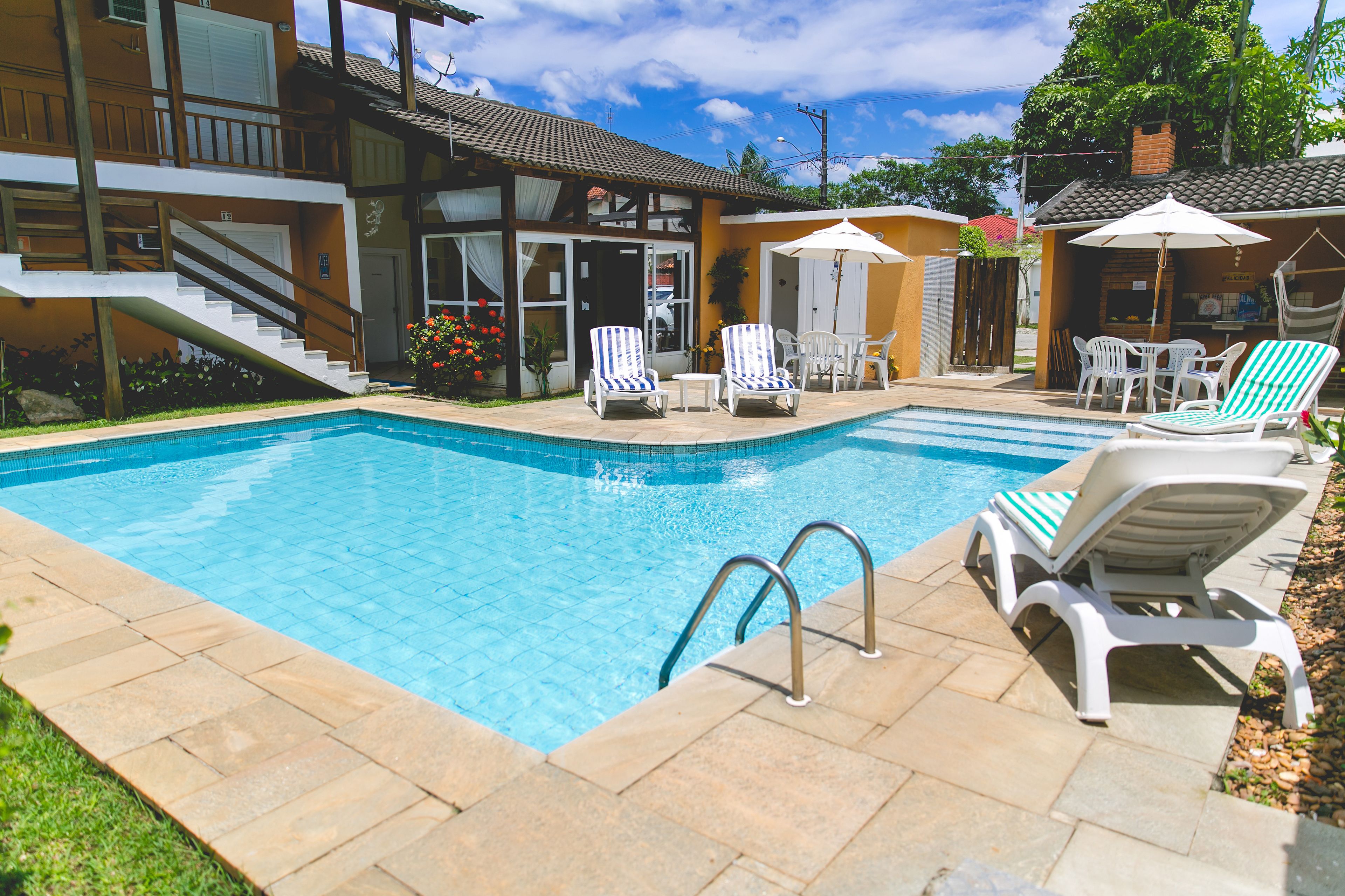 Una piscina al aire libre, sillones reclinables de piscina