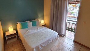 Een hotelkamer met een bed, nachtkastjes en uitzicht.