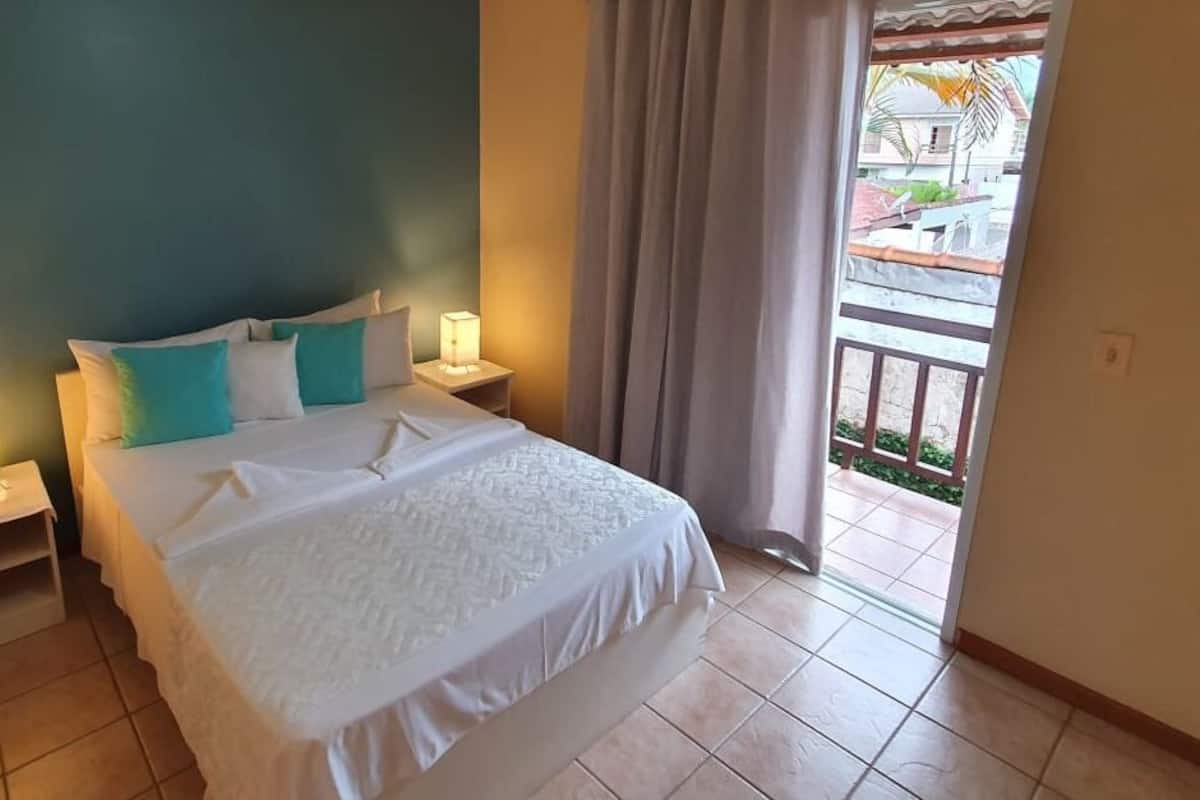 Une chambre d’hôtel avec un lit, des tables de chevet et une vue sur l’extérieur.