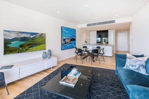Ein modernes Wohnzimmer mit einer Couch, einem Couchtisch und Kunstwerken an den Wänden.