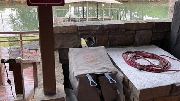 A covered outdoor seating area with a stone table and a sign about fish cooking. - Fun Seekers Getaway!!!! (Hot Springs)