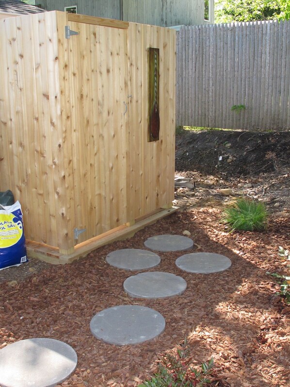 A wooden shed with a metal latch, surrounded by mulch and stepping stones. - 5 bdrm with pool - walk to the Harbor (Montauk)