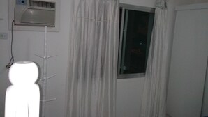 A room with a window, a wall-mounted air conditioner, and a curtain. - Sleeps 6 people, I love this place. (Jardim Praiano)